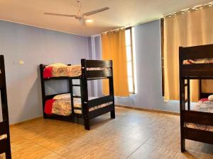 伊察Desert Nights Hostel的客房设有三张双层床和天花板。