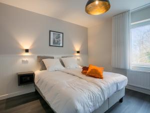 克勒伊斯贝尔亨Villa Col 38的一间卧室配有一张带橙色枕头的床