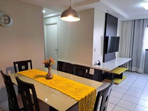 马塞约Apartamento em Maceió com vista para o mar的用餐室,配有一张桌子和花瓶