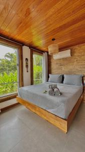 阿拉夏奇巴海滩Pousada Belas Águas的一间卧室设有一张大床、木墙和窗户。