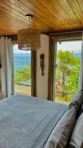 阿拉夏奇巴海滩Pousada Belas Águas的一间卧室设有一张床,享有海景