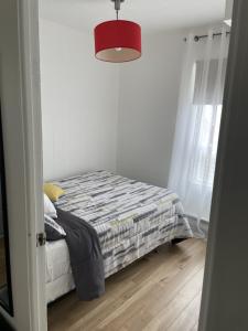 萨格奈4 Pièces, stationnement et tennis的一间卧室配有一张床和红灯
