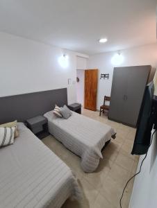 奇莱西托Tres Marías Apart的一间卧室配有两张床和一台平面电视