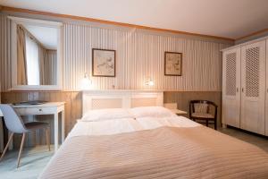 弗林布尔克玛谢特酒店的卧室配有一张白色大床、一张书桌和一张书桌