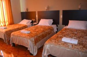 塔克纳HOTEL CASA REAL的一间酒店客房,房间内设有三张床