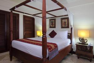 海神庙Villa Ocean的一间卧室配有一张带木制天篷的大床