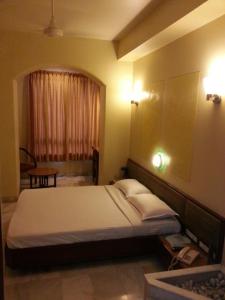 孟买Hotel Ashray International, Sion的酒店客房设有床和窗户。
