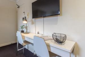 墨尔本Studio Apartment in the heart of Fitzroy的客房设有一张桌子、两把椅子和一台电视
