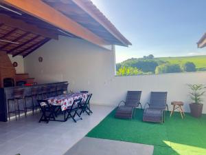 索科罗Chacara em Socorro- SP próx ao centro, com piscina e area gourmet的庭院配有桌椅和绿色地毯。