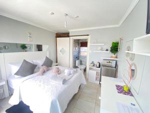 开普敦Kwaaamiii的一间带白色床的卧室和一间厨房