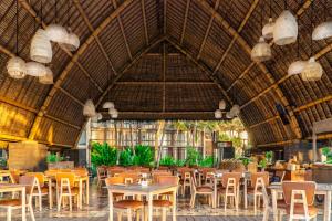 克拉玛斯巴厘岛温德姆塔曼萨里吉瓦度假村的大楼内带桌椅的餐厅