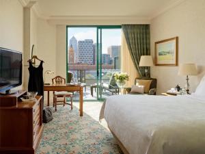 墨尔本墨尔本朗廷酒店的酒店客房配有一张床、一张书桌和一台电视。