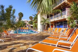 劳德代尔堡海洋沙滩宫酒店的一组橙色躺椅,位于游泳池旁