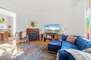 圣保罗Maple Manor的客厅配有蓝色的沙发和电视
