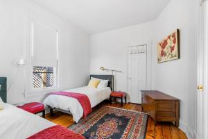 圣保罗Maple Manor的一间卧室配有两张床、一张桌子和一张地毯。