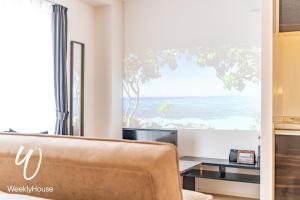 大津WeeklyHouse Silto Crete - Vacation STAY 61955v的带沙发的客厅,享有海滩美景