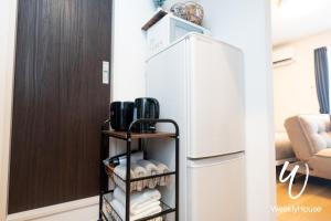 大津WeeklyHouse Silto Crete - Vacation STAY 61955v的厨房配有冰箱和带毛巾的架子。