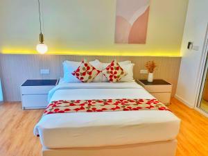 吉隆坡Lila Suites Quill Residences Klcc的一间卧室配有一张红色鲜花的大床