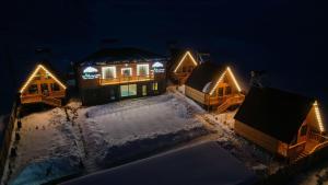 汉克亚万The Mountain Villas的雪覆盖的房屋,晚上有灯