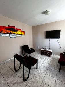 萨帕拉Alquiler temporario zapala Amanecer的客厅配有2把椅子和平面电视