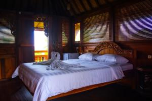 姆杜克The Sangkih Villa Restaurant & Bar的一间卧室配有一张带天鹅的床