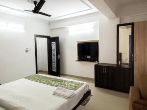 兰奇StayVilla Royal Executive Rooms的一间卧室配有一张床和一台平面电视