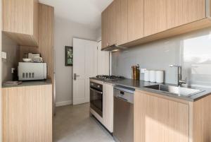 奥兰治Sanlor Suite 2 - Luxury, Comfort & Style的厨房配有水槽和炉灶 顶部烤箱