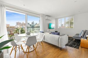 悉尼Chic apartment footsteps from Manly Beach的客厅配有沙发和桌子