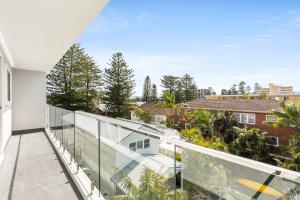 悉尼Chic apartment footsteps from Manly Beach的开放式阳台享有树木和建筑的景致。