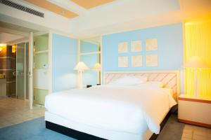 加拉班塞班凯悦酒店的卧室配有白色的床和蓝色的墙壁