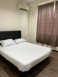 民都鲁1717 Bintulu Homestay 1的一间卧室配有一张带白色床单的床和一扇窗户。