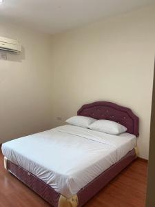 民都鲁1717 Bintulu Homestay 1的卧室内一张带紫色床头板的床