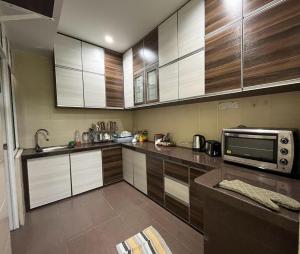 巴特沃思Mega Homestay的一间带木制橱柜和微波炉的厨房