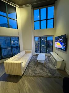 温哥华LUXURY LOFT IN DOWNTOWN VANCOUVER的客厅设有大沙发和电视