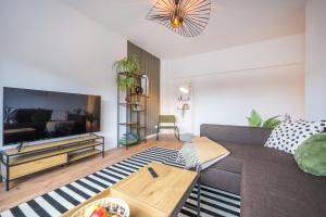 科布伦茨NEU: 100m² - ideal für Familien/Geschäftsr. - HBF的带沙发和电视的客厅