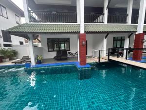哈德姚Amara Beach Resort Koh Phangan的房屋前的游泳池