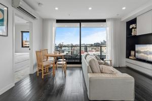 墨尔本Elegant Collingwood Apartment with City Views的客厅配有沙发和桌子