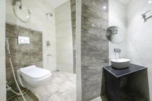 坎普尔FabHotel Uday Villa的一间带卫生间、水槽和镜子的浴室