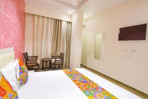 坎普尔FabHotel Uday Villa的配有一张床和一台平面电视的酒店客房