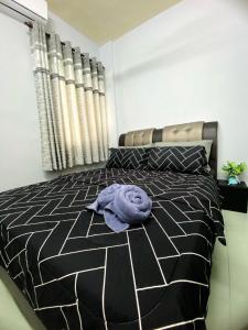 波德申Izdisa Muslim Homestay Teluk Kemang Groundfloor unit with Pool view的卧室床上的紫色毛巾