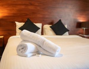 贝尔蒙特Belmont Hotel Lake Macquarie的在酒店房间床上的一堆毛巾