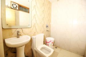 新德里Hotel Lav-Kush的一间带卫生间、水槽和小便室的浴室