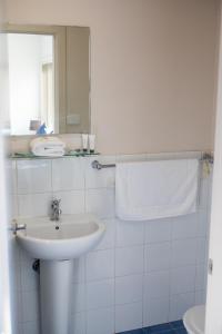 贝尔蒙特Belmont Hotel Lake Macquarie的白色的浴室设有水槽和镜子
