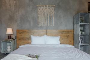 头顿Babylon Mini Resort的卧室配有白色的床和木制床头板