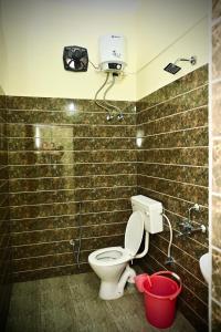 古瓦哈提Queen's Residency的一间带卫生间、淋浴和桶的浴室