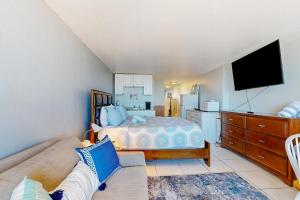 代托纳海滩Pirates Cove Unit G22的一间卧室配有一张床、一张沙发和一台电视。