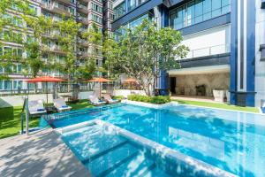 曼谷SILQ Hotel & Residence, Managed by The Ascott Limited的大楼庭院内的无边泳池