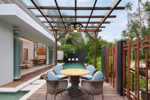 拉古洼Four Points by Sheraton Bintan, Lagoi Bay的一个带桌椅的庭院和一个游泳池