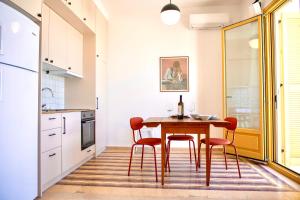 爱琴娜岛Port view apartment Aegina的厨房配有木桌和红色椅子