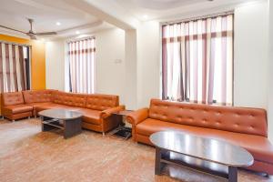 阿格拉FabHotel Prashant Palace的一间设有皮沙发和桌子的等候室
